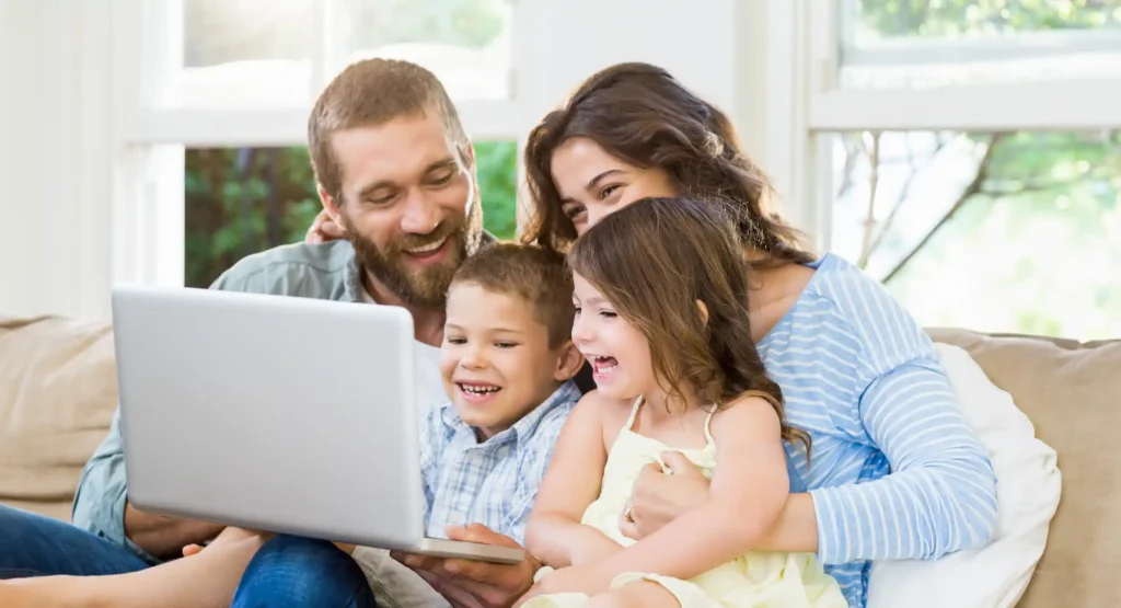 family sitting around computer Affordable-Connectivity-Program-and-Lifeline-Credits-Featured-Image-december-2023