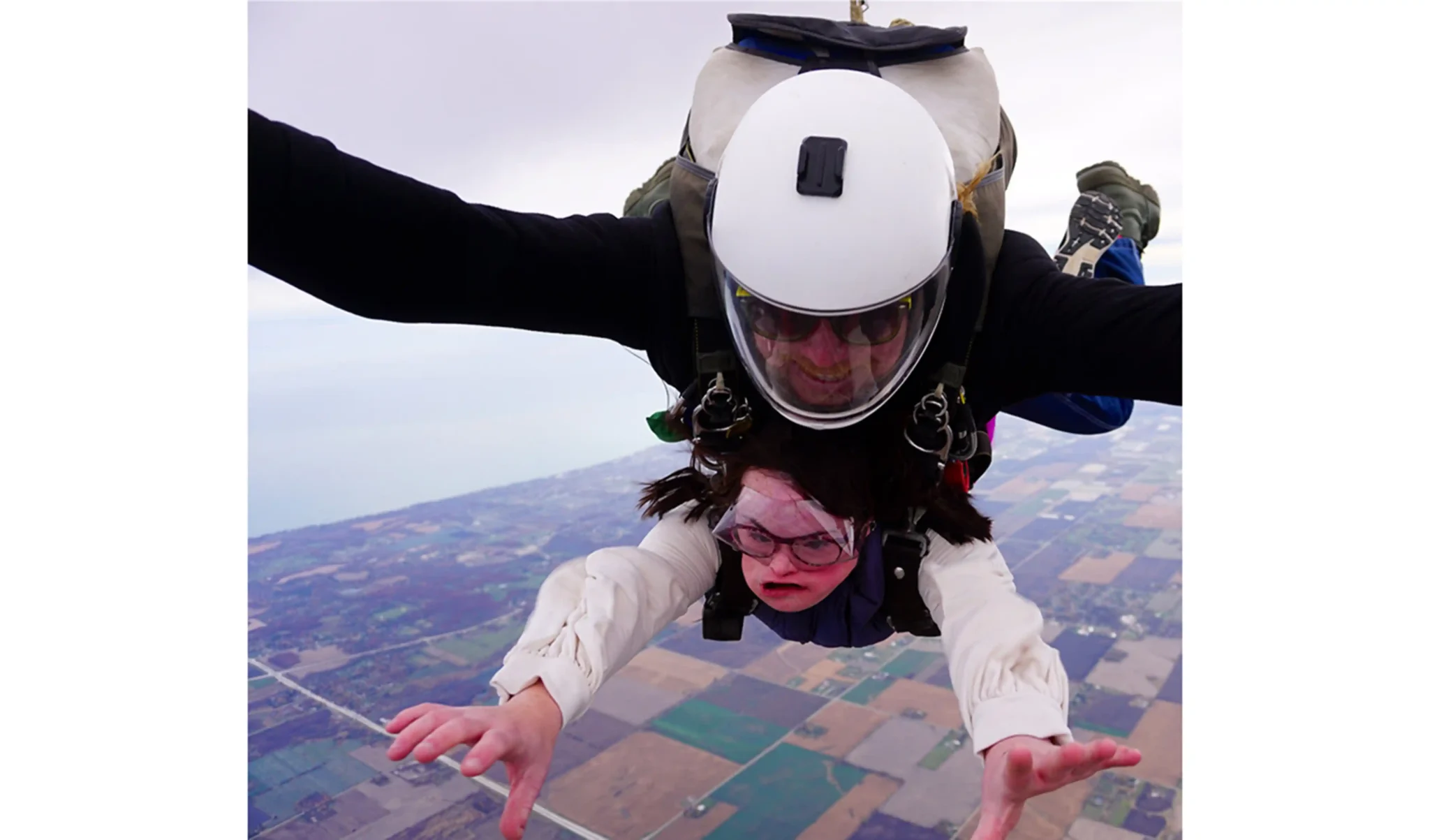 Two people skydiving, with the instructor behind the participant.